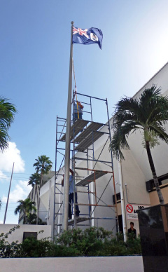 A Public Works Department team fixes the flag outside the Court House on Wednesday. - Photo: Carol Winker