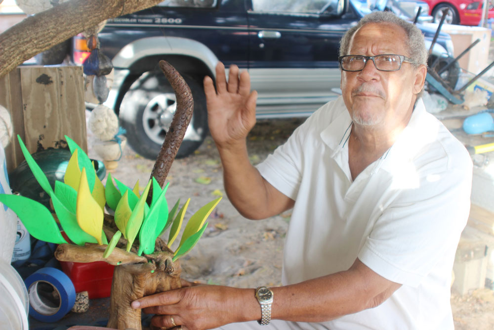 East End artist Edney McLean works on a dried wood creation for the show.