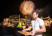 Plenty to savor at Taste of Cayman Dan Hollis, of Margaritaville, delivers some of his award-winning drinks to judges in the mixology competition as fireworks fill the air at the annual Taste of Cayman at Festival Green at Camana Bay. Mr. Hollis won the competition. - PHOTO: TANEOS RAMSAY