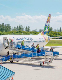 Passengers disembark from a Cayman Airways jet using one of the four new ramps that airline officials say will allow for safer and more comfortable boarding and deplaning.