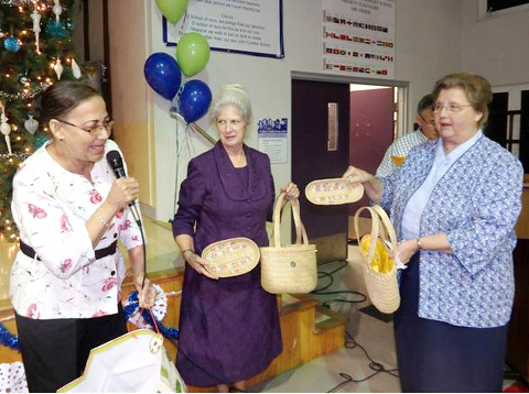 Ula (Elicia) Ebanks presents thatch baskets to Rev. Genie Dickerson and Rev. Brenda Wallick.