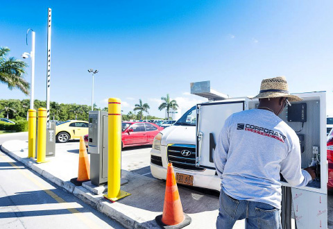 A workman installs new ticket gates and equipment at the Owen Roberts International Airport parking lot. The new system is scheduled to be operational by March. – PHOTO: TANEOS RAMSAY