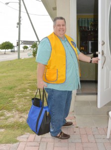 Lion Eric Anderson delivering a pantry shopping bag.