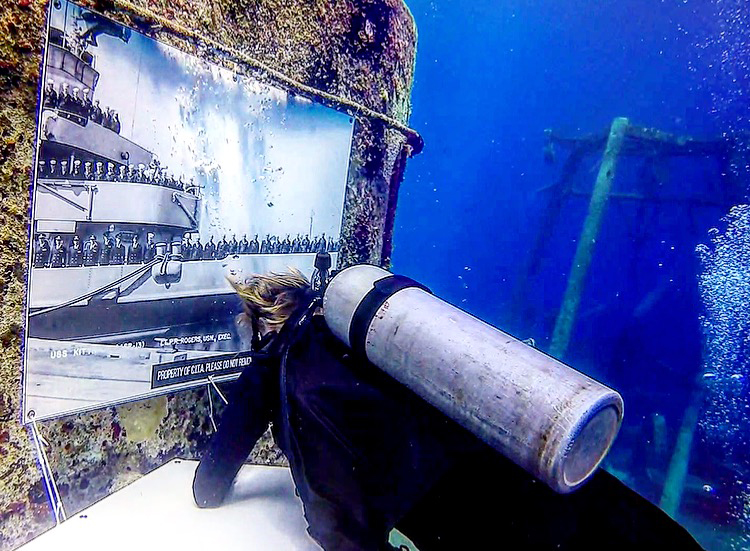 Divers place the finishing touches on one of several photos for the 5th anniversary underwater museum.