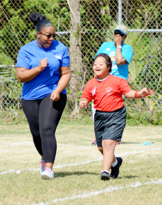 A member of house Barracuda cheers on a young Snapper student during his race.