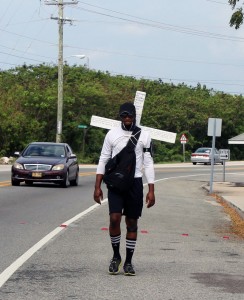 Granville Williams walks through Savannah on his way to East End with his cross on Thursday. - Photo: Jewel Levy