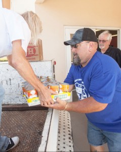 Keith Keller, president of the Cayman Islands Motorcycle Riders Association, unloads a donation of food to Meals on Wheels.