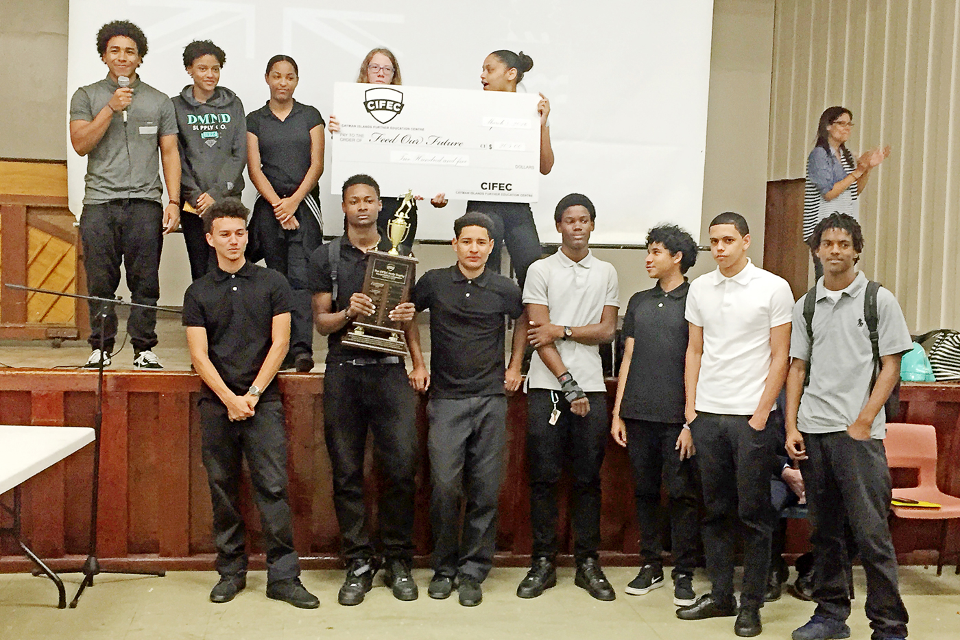 Tournament champions Future Elites, along with CIFEC students who helped organize the event, gather at Tuesday’s check presentation to Feed Our Future.