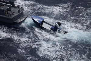 The boat on which the five missing boaters had been aboard is towed back to Grand Cayman Tuesday by a marine police vessel. - PHOTO: RCIPS
