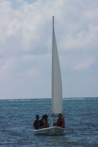 Students sail a dinghy to shore.