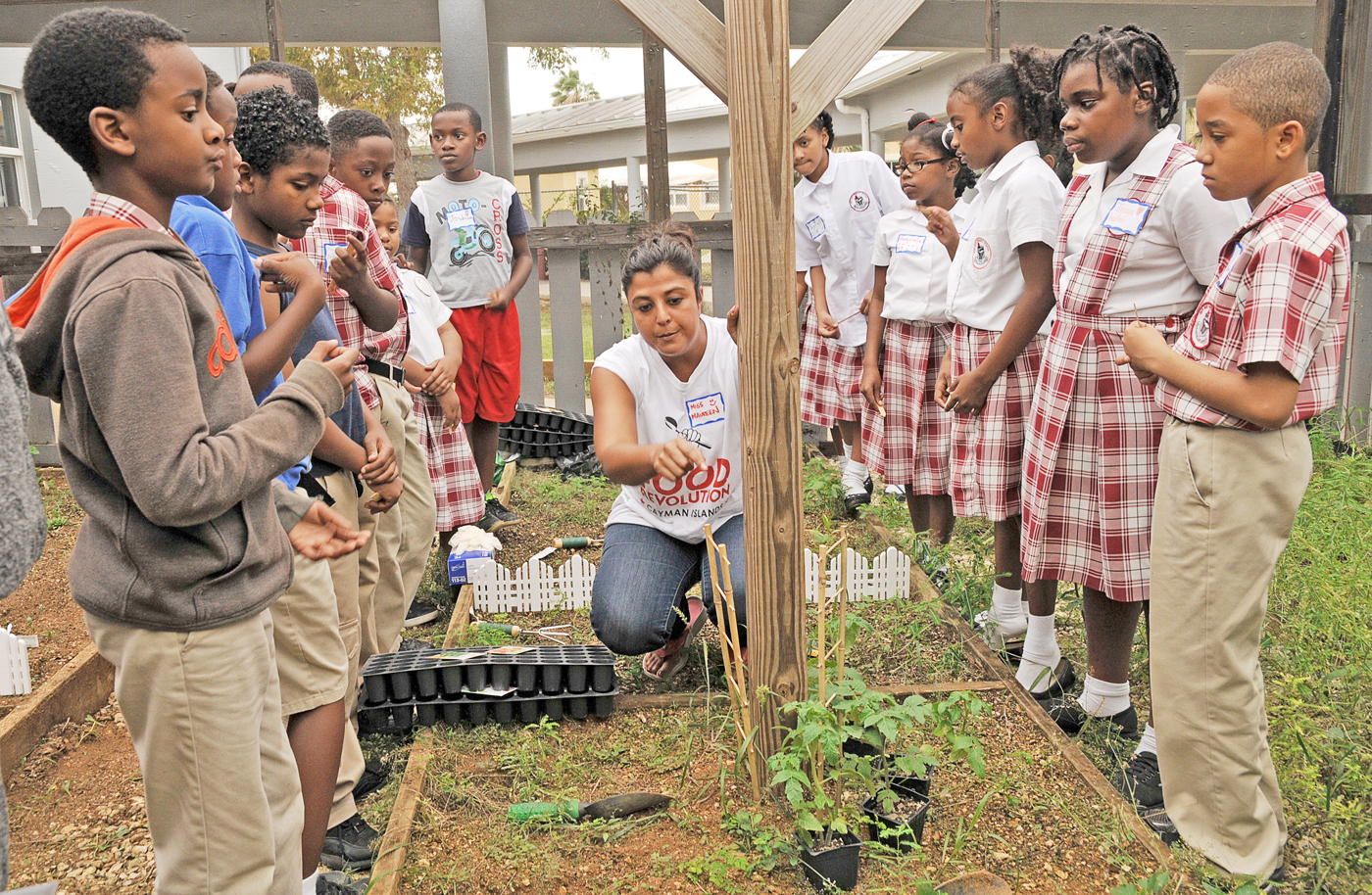 Food Revolution ambassador Maureen Cubbon demonstrates how to prepare the school garden plots for planting. – PHOTO: Alma Chollette