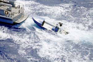 The boat on which the five missing boaters had been aboard is towed back to Grand Cayman on March 8, two days after the boaters were reported missing. - PHOTO: RCIPS