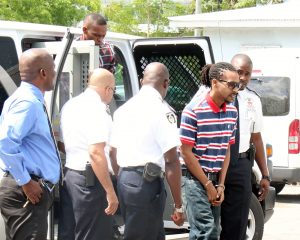 Justin Ramoon, front, striped shirt, and Osbourne Douglas, back, step from the prison van outside the Globe Bar on Wednesday.