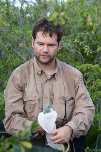 The National Trust's enviromental programs manager Paul Watler prepares to release a young blue iguana into the wild in February 2016. - PHOTO: Stephen Barten