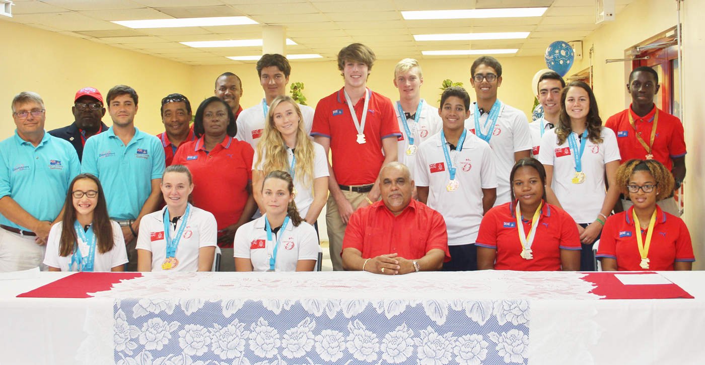 At a press conference on Friday, 22 swim and track and field medal winners from two separate Carifta games in Grenada and Martinique pose with their coaches, sports officials and Sports Minister Osbourne Bodden.
