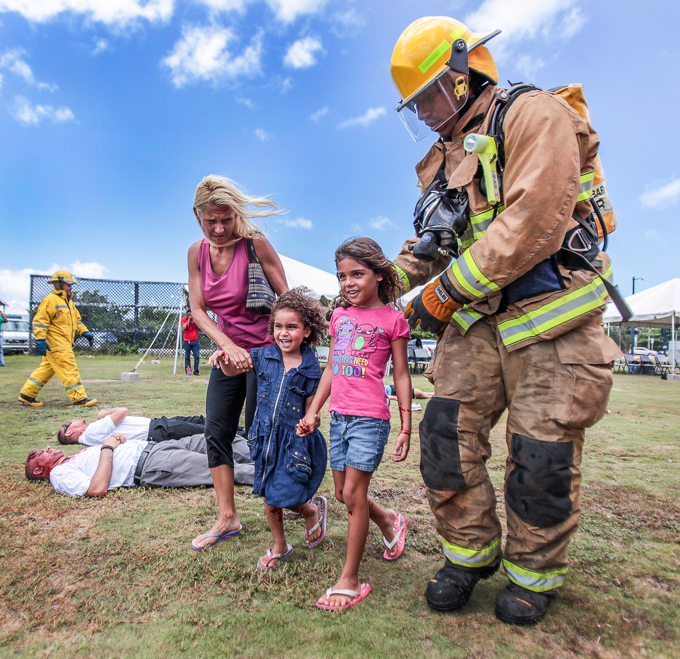 Red Cross volunteer Adrienn Sergios and her daughters, Jessica, 6, and Christina, 4, are helped by firefighters. 