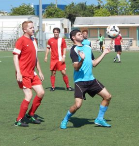 Carlos Andrade of Boca holds off Maples defender Stuart Rowe.