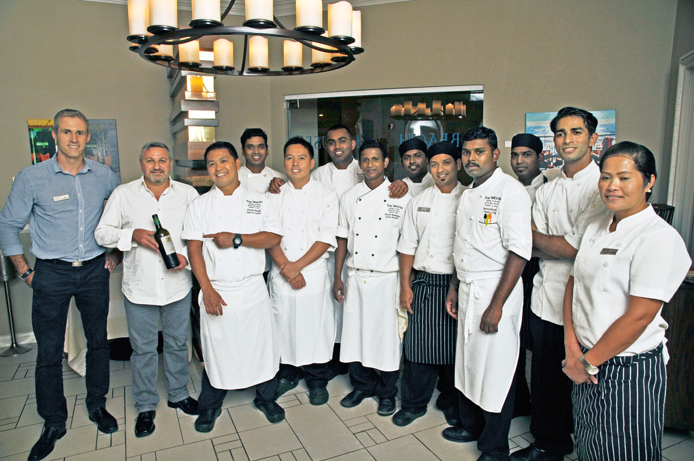 Beach House Restaurant Manager Norbert Szalay, left, Tortuga Fine Wines & Spirits Head of Wine Division Massimo Consolini, second from left, along with the chef and kitchen staff.