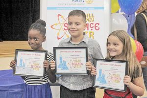 Joanna Robinson, James Banks, and Iona Nicol show off their first place awards in the life science category for their solar oven project.
