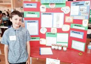 Connor Finch with his winning project ‘Is it Sugar?’ on the comparative effects of Coke, Diet Coke and soda water on teeth.
