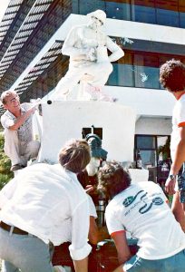 The film crew gathers around the 'statue' of Durty Reid Walker in George Town.
