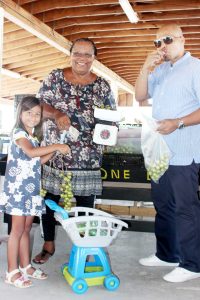 Nyla Mahadeo, Marilyn Nasirun and Aaron 'D-Docta' Solomon dive into some guineps at the farmers market. - Photos: Jewel Levy