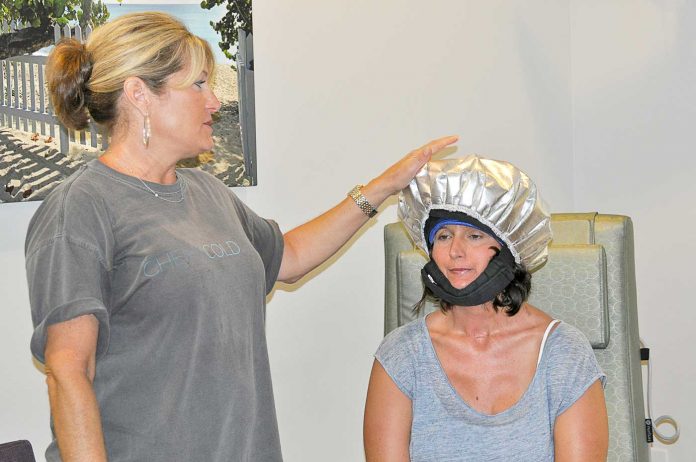 Lizzy-Cronin,-Founder-and-Owner-of-ColdCaps.com-giving-the-Chemotherapy-Unit-staff-a-demonstration-on-how-to-properly-apply-a-cold-cap-with-the-assistance-of-Tori-Croft