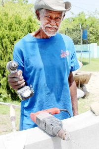 Mr. McLaughlin works on a cement wall on John McLean Drive.