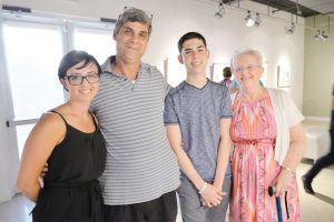 From left, Gallery director Natalie Urquhart with Michael McLaughlin, Nathan McLaughlin, and Heather McLaughlin, wife of the late Ray McLaughlin, whose work is on show in the exhibition.