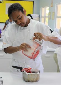Leslie Anderson puts blended strawberries into a pot.