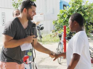 Master of ceremonies Kevin Morales presents a prize to 8-year-old cyclist Nathin Irving, visiting from New Jersey, who took part in the 10km ride with his father Euclid Irving.