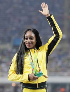 Elaine Thompson celebrates her gold medal for the women's 100m sprint.