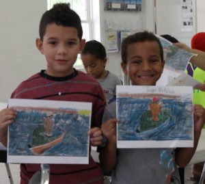 Isaiah Conolly and Taygan McFarlane hold up their coloring pages of Conroy Ebanks’s artwork.