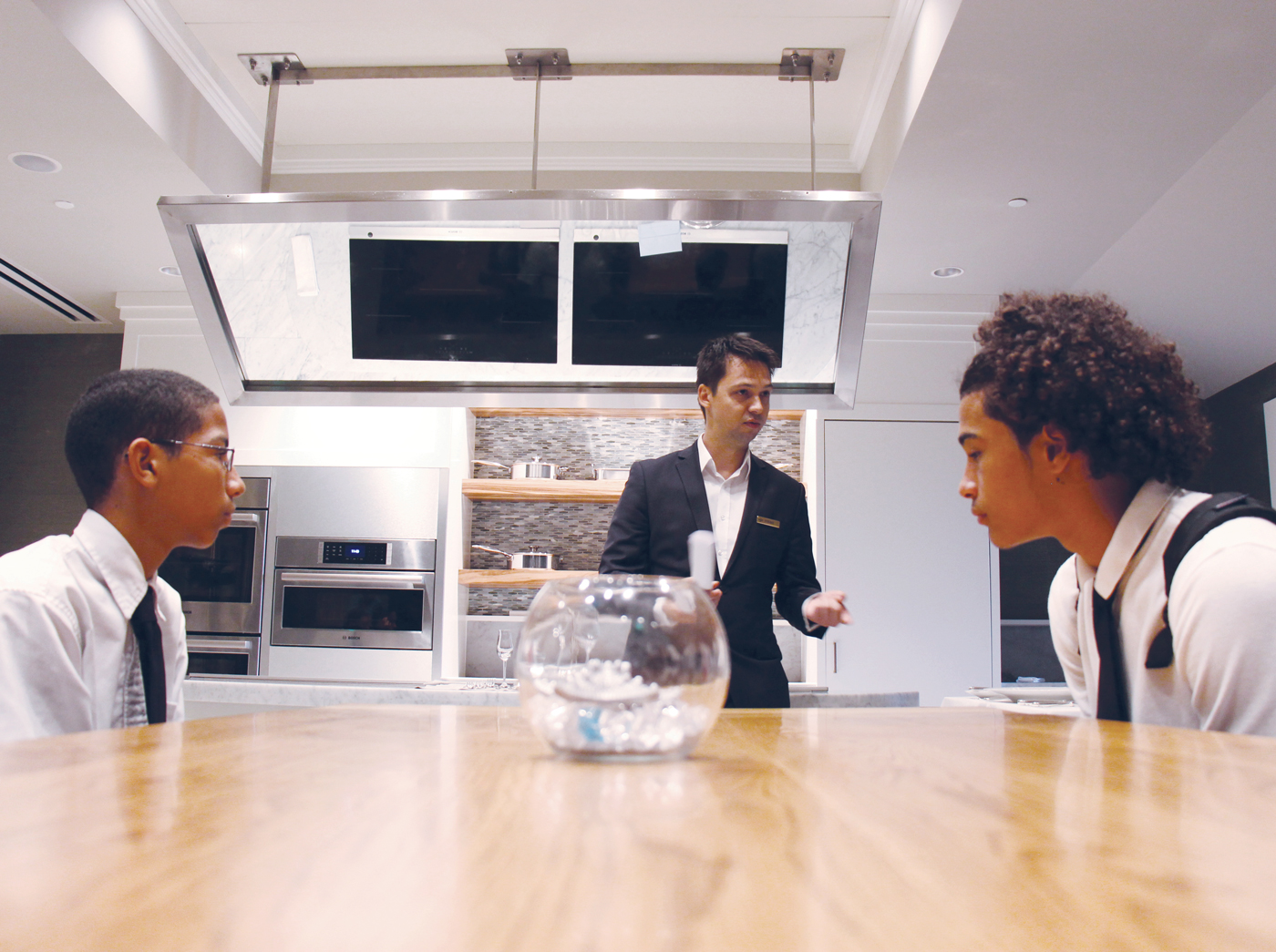 George Duran and Ernesdo Ebanks listen as Peter Baics, food and beverage manager at Blue restaurant, talks about table etiquette.