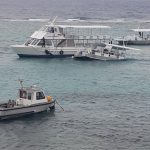 Two boats towed in harbor in high seas