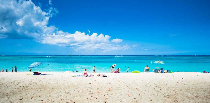 Tourists relax on Grand Cayman's Seven Mile Beach