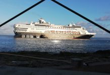 Tugboat pushes drifting cruise ship into position