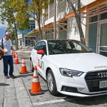The car that rents by the minute… Compass journalist James Whittaker unlocks a Zun vehicle at Camana Bay
