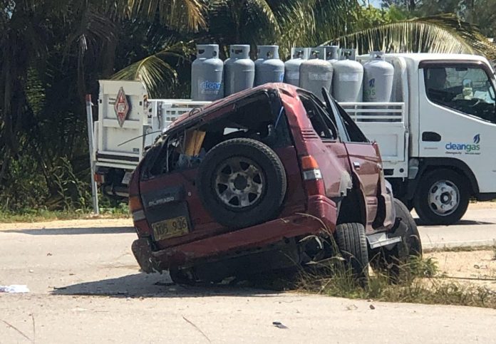 The crumpled SUV lies at the side of Rex Crighton Boulevard Friday.