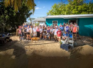 Volunteers gather to help build a container home for a West Bat family in need