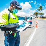 Roadblocks to continue A police officer writes up a ticket, which is issued to a motorist who broke the soft curfew