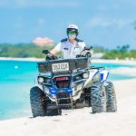 Government considers easing beach ban and Sunday lockdown An officer on ATV beach patrol.