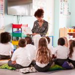 End-of-term school days lengthened to make up shortfall Teacher with students in desegregated classroom