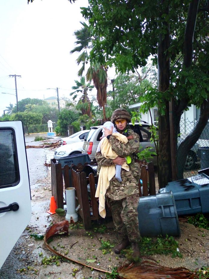 Cayman Islands Regiment commander comforts baby after Tropical Storm Grace