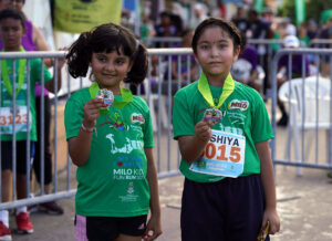 Arshiya Anuj (R) and friend show off their Milo Kids Fun Run Medals