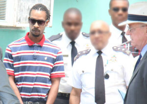 Justin Ramoon at a site-visit at the Globe Bar in George Town during his trial for murder (officers' faces have been deliberately blurred).