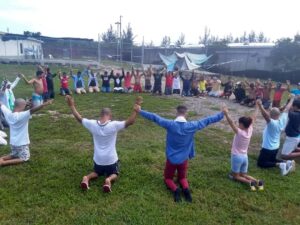 Cubans gather together in a prayer circle over the weekend in a detention centre on Grand Cayman.