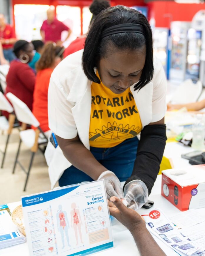 Rotarian and registered nurse Zelta Gayle takes a blood sample
