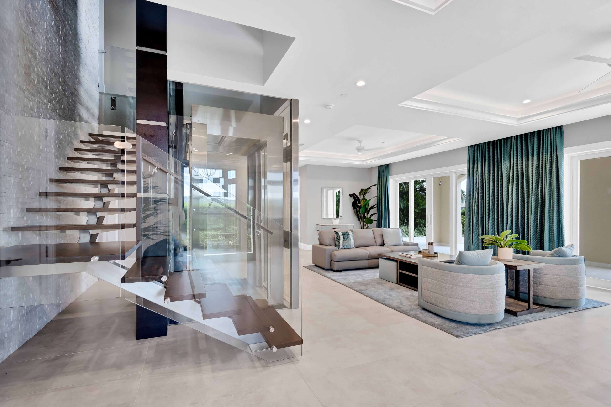 Upon entering the property the huge open-plan living room includes wet bar, floating staircase and glass elevator Credit: Cayman Luxury Auctions