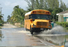 Residents assess water damage as Cayman recovers from deluge A school bus navigates rain-soaked roads to drop off children after classes resumed as usual on Tuesday. - Photos: Dana Kampa